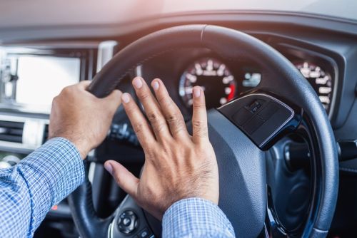 Hand man pushing car horn while driving car concept.