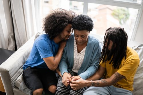 Sons consoling mother after wrongful death of husband