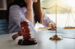 woman on phone behind gavel and scales of justice