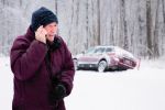 Senior man calling for help during snow storm after an auto accident due to weather conditions.